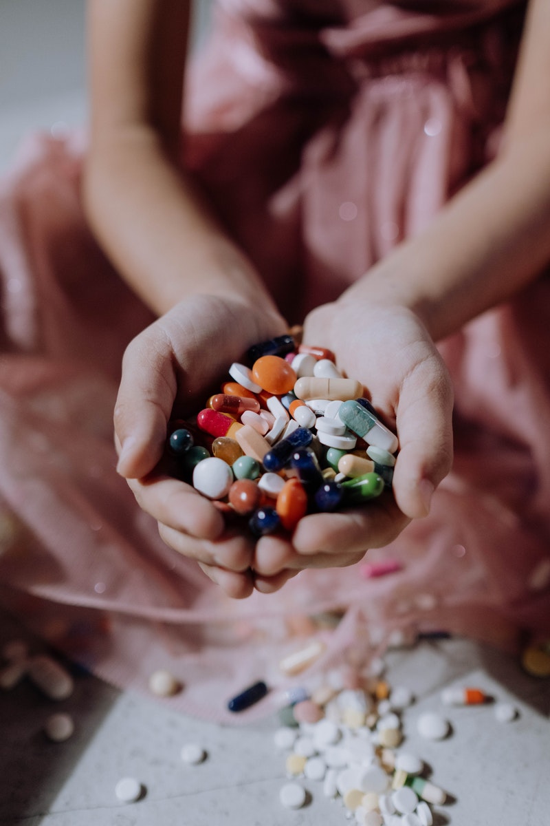 A Handful of Assorted Medicines on a Child's Hands