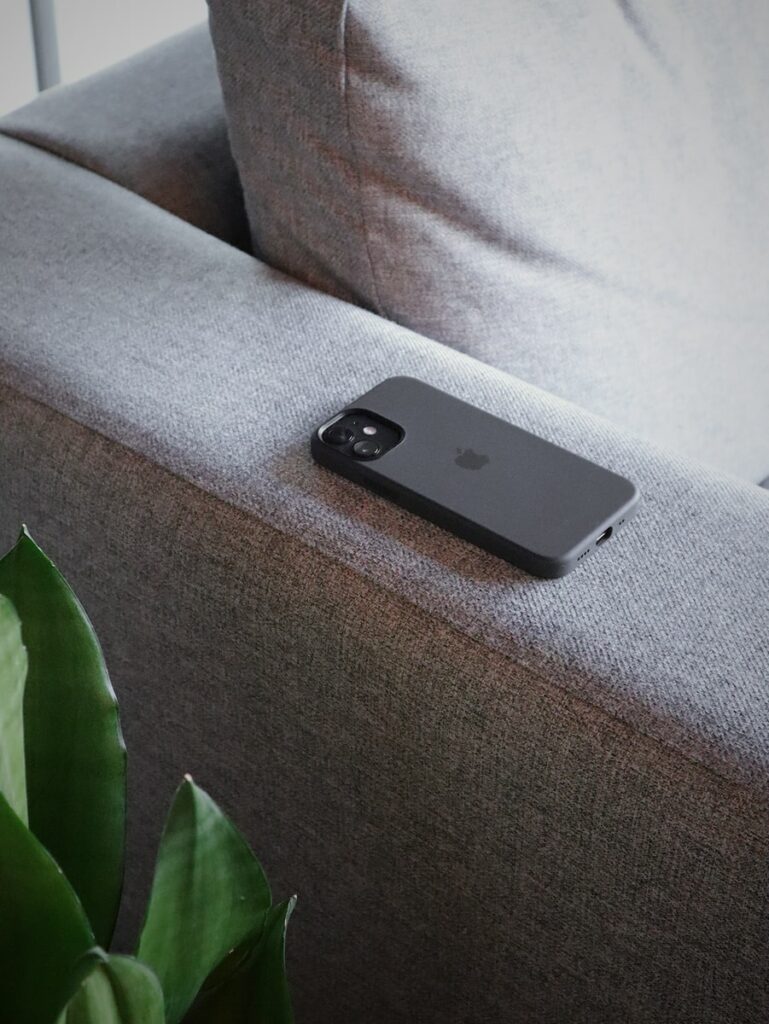 black iphone 5 on gray sofa