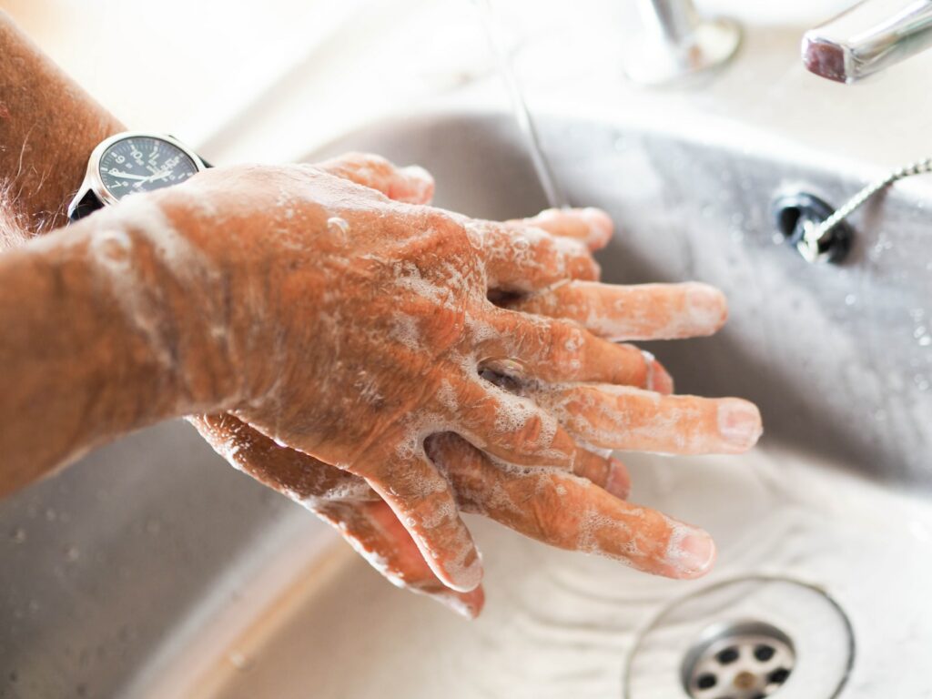 person washing hands on sink