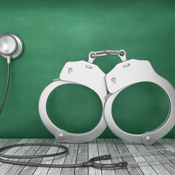 Stethoscope with Handcuffs on Chalkboard Background - 3D Rendering
