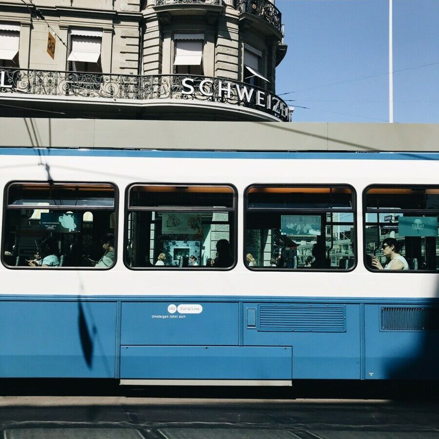 blue and white train near building during daytime